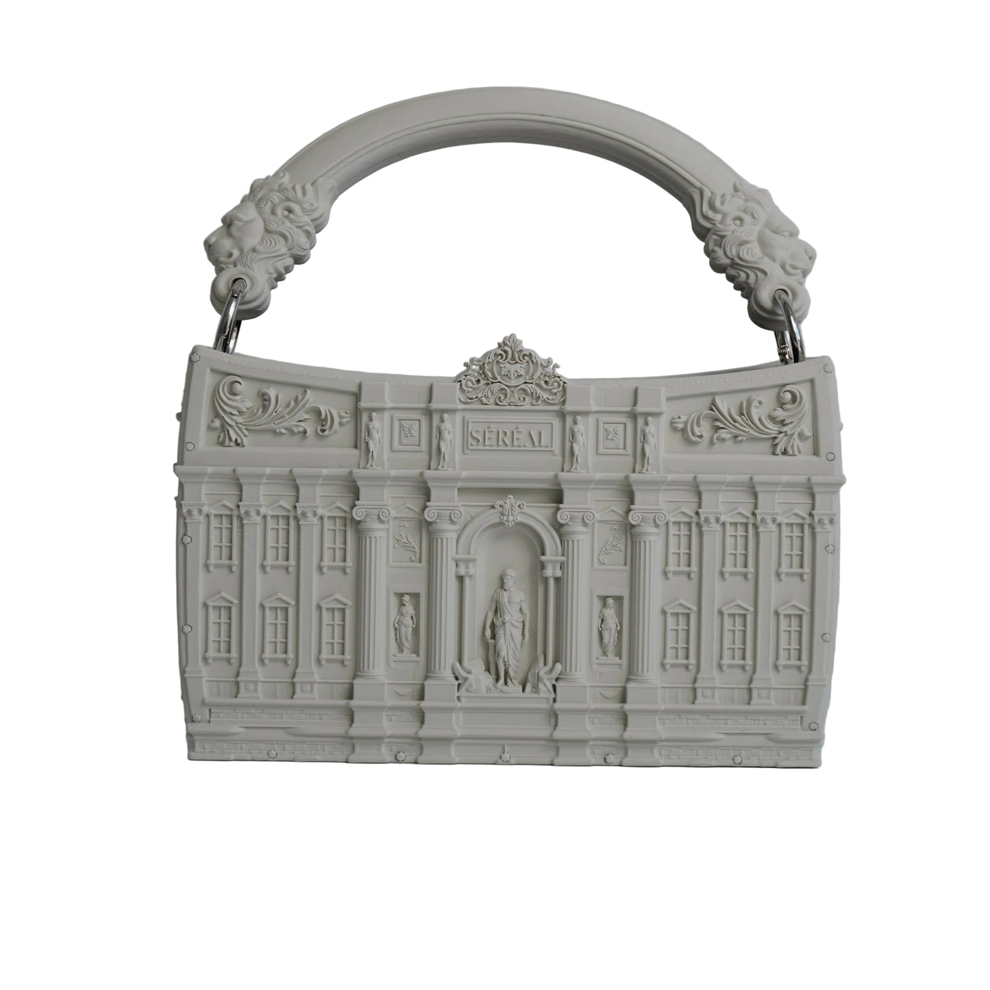 A light gray, sculptural handbag designed to resemble a classical building facade, featuring an integrated arched handle with lion head details, set against a neutral gray background with a soft reflection on the surface below.