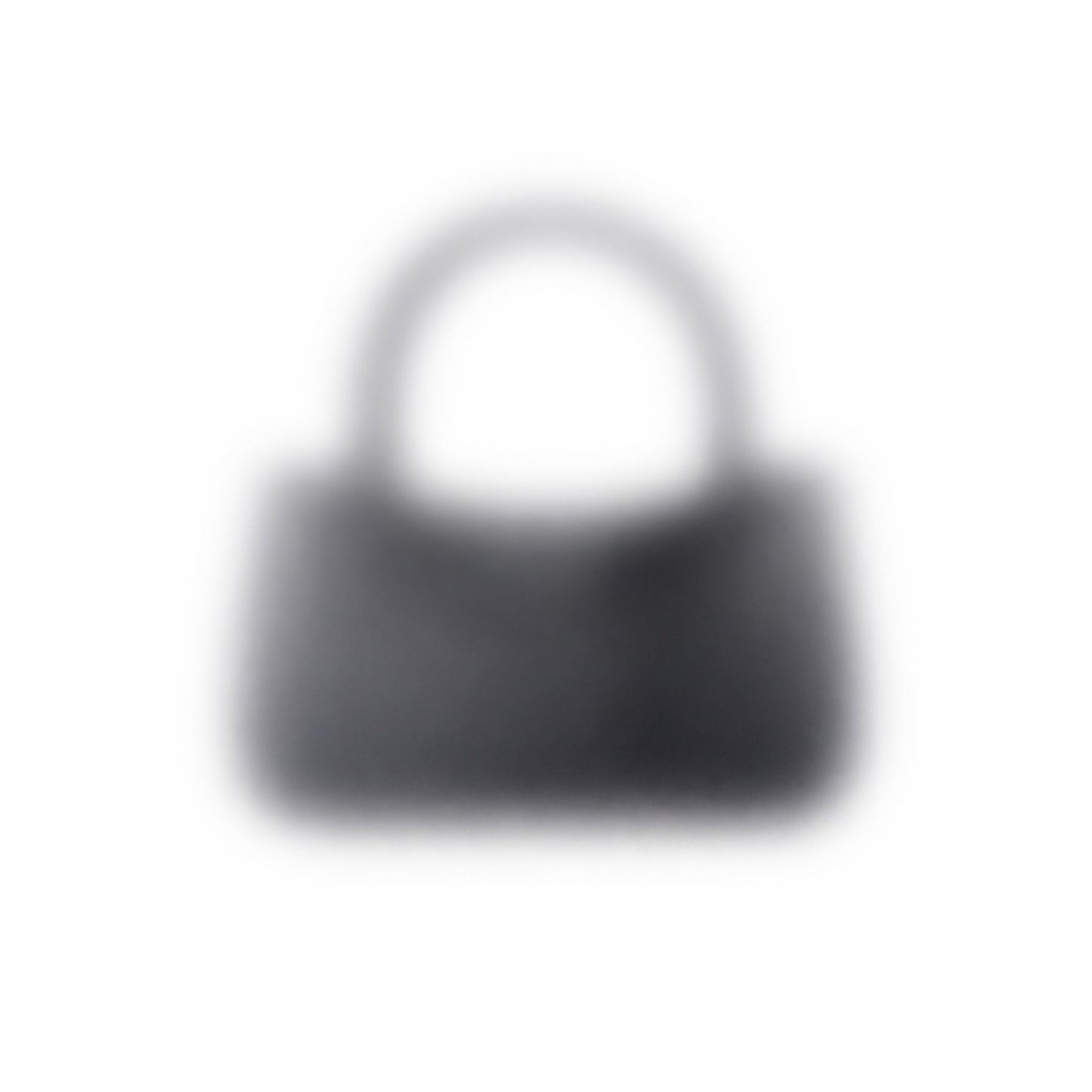 A dark-colored "Mystery bag" 3D-printed handbag with a short handle is seen against a white background. The image is blurry, making its details and texture unclear.