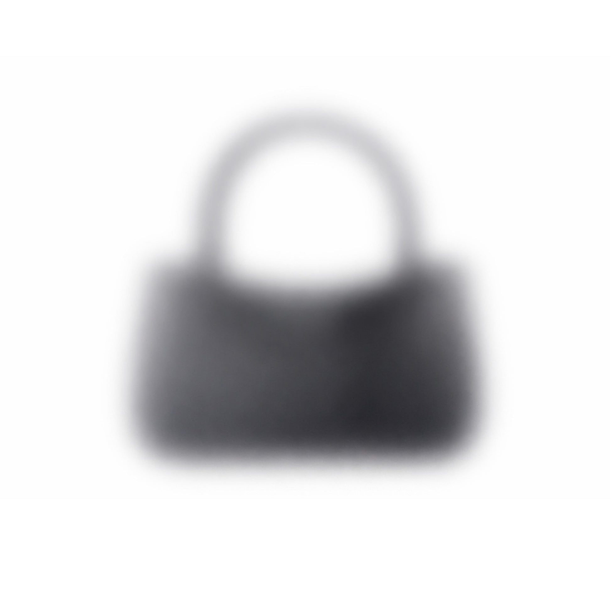 A dark-colored "Mystery bag" 3D-printed handbag with a short handle is seen against a white background. The image is blurry, making its details and texture unclear.