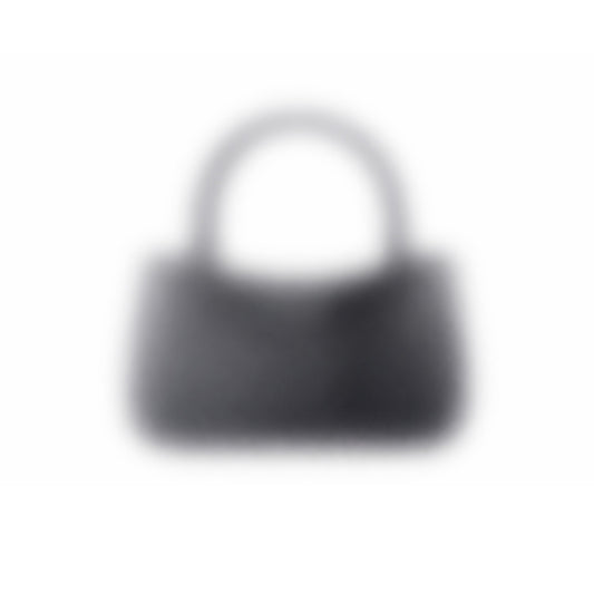 A dark-colored "Mystery bag" 3D-printed handbag with a short handle is seen against a white background. The image is blurry, making its details and texture unclear.