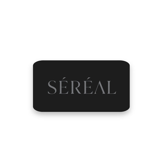 A black rectangular card with "SÉRÉAL" in gray uppercase letters is centered on white, embodying modern luxury—the ideal SÉRÉAL Digital Gift Card for any 3D-printed handbag lover.