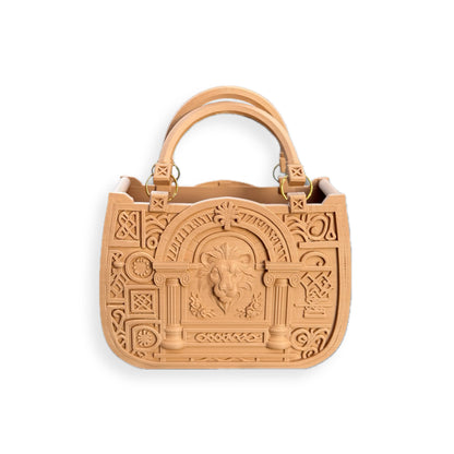 The JUSTICE&POWER 3D-printed handbag features a tan neoclassical design with embossed columns, geometric patterns, a central ram’s head motif, two sturdy handles, and gold-tone hardware on a white background.