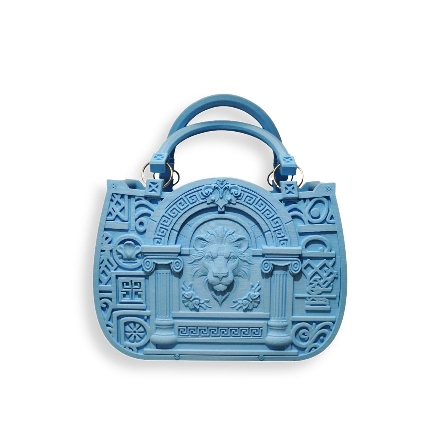The JUSTICE&POWER 3D-printed handbag is blue with ornate embossed geometric patterns and a central lion head motif, double handles, and a sculptural, structured neoclassical shape, shown against a white background.