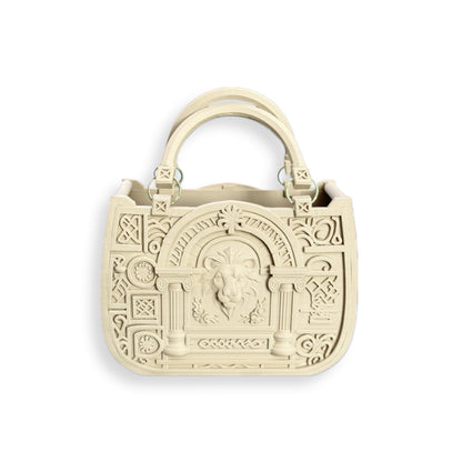 The JUSTICE&POWER 3D-printed handbag in beige features two handles, embossed columns, geometric patterns, and a central ram's head motif on the front in neoclassical style.