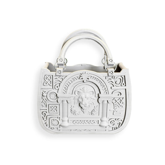 The JUSTICE&POWER 3D-printed handbag is white, neoclassical-inspired, with ornate embossed patterns, a central lion head motif, dual handles, and decorative architectural front details.